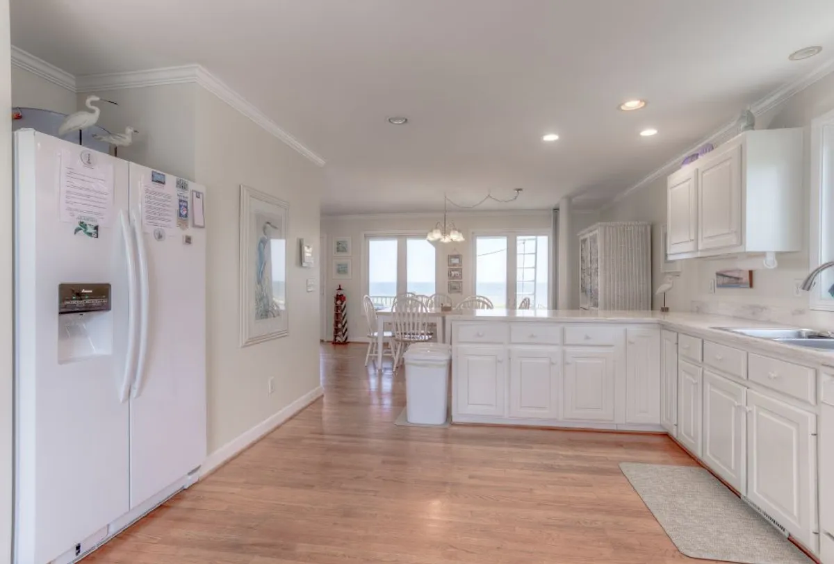 A chef-inspired kitchen featuring white cabinetry, a spacious kitchen island, and an adjacent dining area flooded with natural light. The layout encourages interaction, with plenty of room for cooking, socializing, and gathering with family and friends.